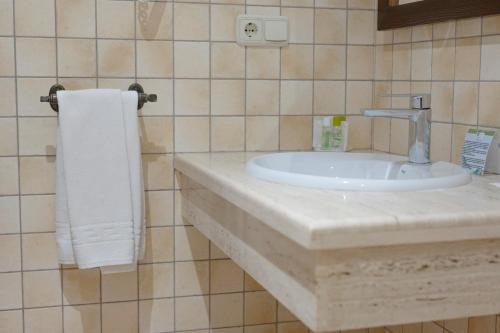 baño con lavabo y toalla blanca en María de Molina, en Úbeda