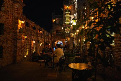 two people sitting at a table in an alley at night at Terra Firma Hotel Boutique in Villa Carlos Paz