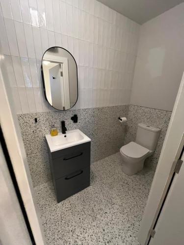 a bathroom with a sink and a toilet and a mirror at Sutcliffe House in Dublin