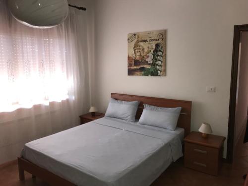 a bedroom with a bed with white sheets and a window at Casa Giulia in Mestre