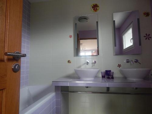 Chambres d'hôtes l'Armancière في سانت مارسيلين: حمام به مغسلتين وحوض استحمام ومرآة