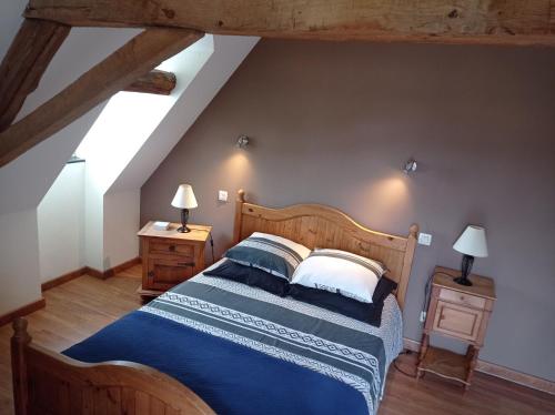 a bedroom with a large wooden bed with blue sheets at La Closerie de la Hérissière in La Jaille-Yvon