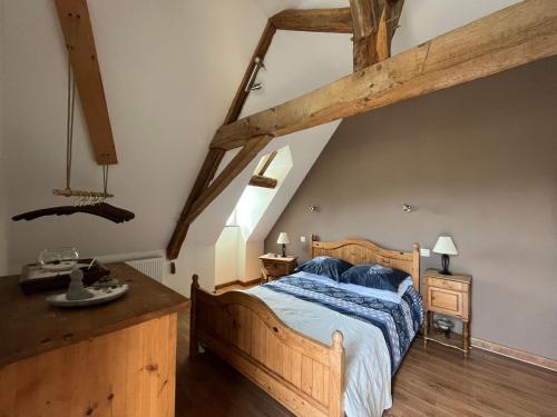 a bedroom with a wooden bed with a blue comforter at La Closerie de la Hérissière in La Jaille-Yvon