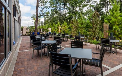 a row of tables and chairs on a patio at Crowne Plaza Shenandoah - The Woodlands Area by IHG in The Woodlands