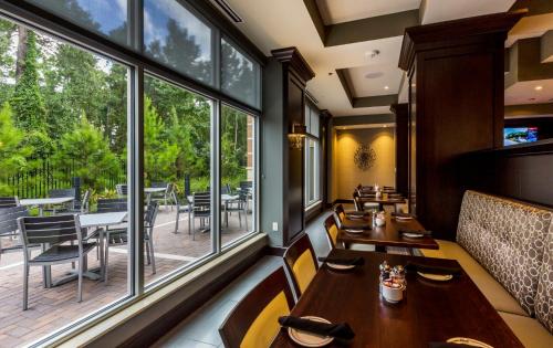 a restaurant with tables and chairs and large windows at Crowne Plaza Shenandoah - The Woodlands Area by IHG in The Woodlands