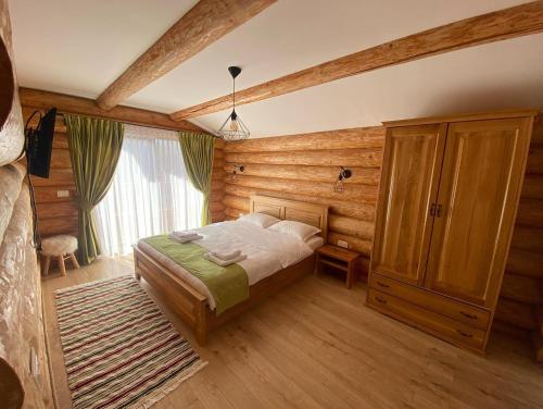 1 dormitorio con 1 cama y pared de madera en Cabana 9 en Borşa