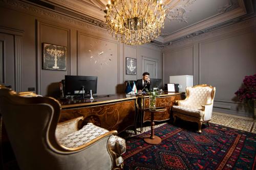 mężczyzna siedzący przy biurku w pokoju w obiekcie Sapphire Bayil Hotel w mieście Baku