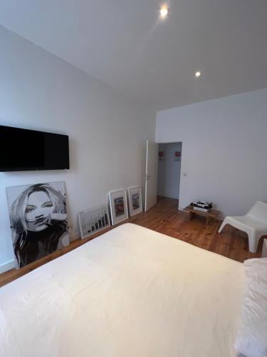 a bedroom with a white bed and a flat screen tv at City center boutique apartment in Funchal