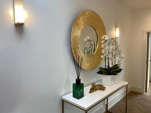 a mirror on a wall next to a table with flowers at Apartment 11 Penthouse 2 bedrooms, sleeps 4 in York