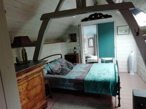 um quarto com uma cama e uma cómoda num quarto em Gîte des pêcheurs em Cantenay-Épinard