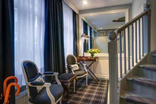 a hotel corridor with chairs and a table and stairs at Canalside House - Luxury Guesthouse in Bruges