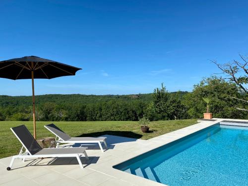 - une piscine avec 2 chaises et un parasol dans l'établissement Domaine de Cazal - Gîte 4 pers avec piscine au cœur de 26 hectares de nature préservée, à Saint-Cyprien