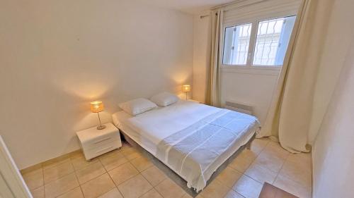 une petite chambre avec un lit et une fenêtre dans l'établissement Miremer, à Sainte-Maxime