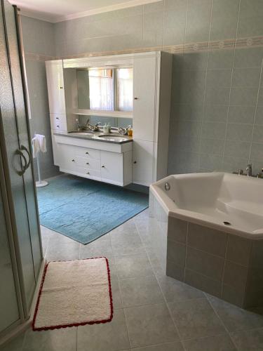 ein weißes Badezimmer mit einer Badewanne und einem Waschbecken in der Unterkunft Villa Octogon in Leukerbad