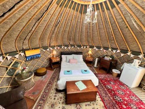 a large room with a bed in a yurt at Stonehenge Campsite & Glamping in Berwick Saint James