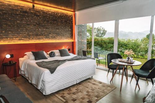 a bedroom with a bed and a brick wall at Pousada Cantelli in Bento Gonçalves