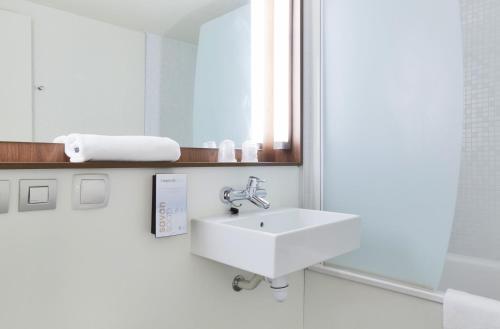 een badkamer met een wastafel en een spiegel bij Campanile Lille Sud - CHR in Lille