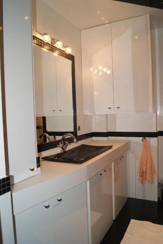 a white kitchen with a sink and a mirror at Living Room in Tarnów