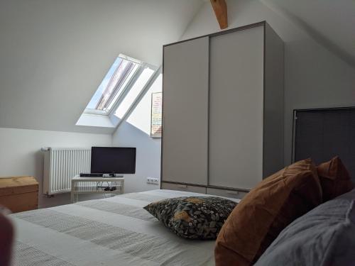 1 dormitorio con 1 cama grande y TV en Spatzennest und Rabennest, en Sugenheim