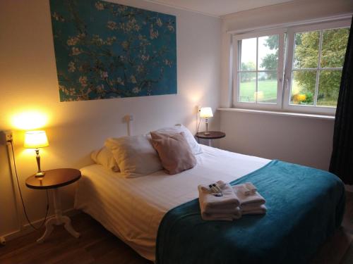 Un dormitorio con una cama con dos toallas encima. en B&B-Hotel de Joremeinshoeve, en Kaatsheuvel