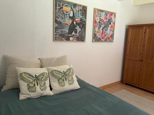 1 dormitorio con 1 cama con 2 almohadas de mariposa en Villa Bella, en Castelldefels