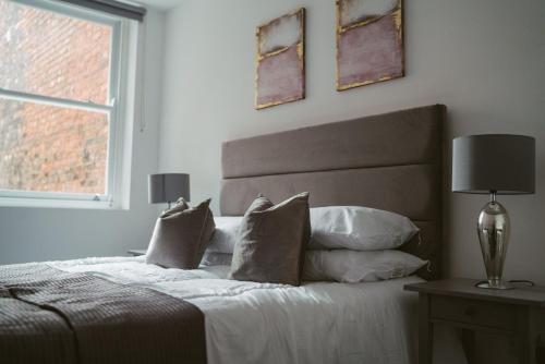 - une chambre avec un lit doté d'oreillers et d'une fenêtre dans l'établissement Apartment 4 2 bedroom, sleeps x 6, à York
