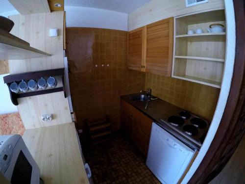 une petite cuisine avec un évier et une cuisinière dans l'établissement Studio cabine 4 pers, balcon exposé Sud, au centre de Valloire, proche remontées mécaniques et commerces - FR-1-263-477, à Valloire