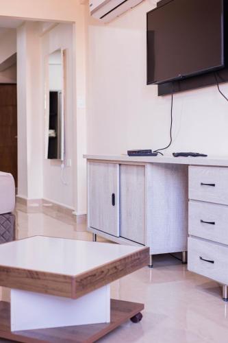 a living room with a table and a tv at Liebling Hotel Ciudad del Este in Ciudad del Este