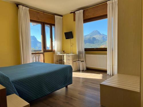 a bedroom with a bed and a view of a mountain at Hotel Giardino in Pieve di Cadore