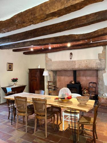 a dining room with a table and chairs and a fireplace at Le Mas de Coursac in Quissac