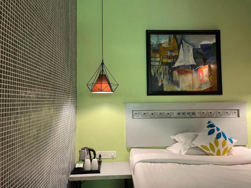 a bedroom with a bed and a picture on the wall at The Art Hotel by VIA VARANASI in Varanasi
