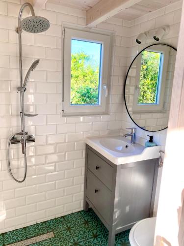 a white bathroom with a sink and a mirror at Bohemian Eco lodge át lake Balaton in Kisapáti