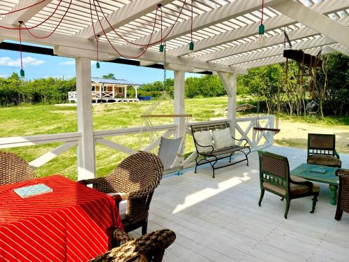a patio with a table and chairs under a white pergola at Bohemian Eco lodge át lake Balaton in Kisapáti