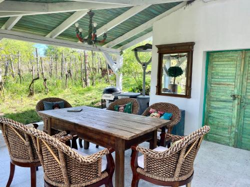 a wooden table and chairs on a patio at Bohemian Eco lodge át lake Balaton in Kisapáti