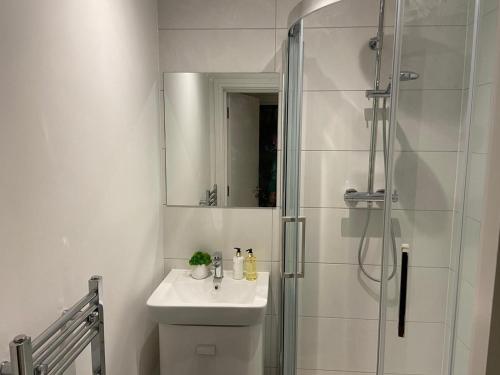 a white bathroom with a sink and a shower at Apartment 5 4 bedrooms, sleeps x 15 in York
