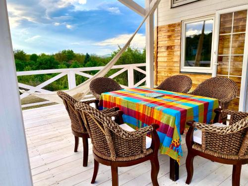 a table and chairs on a porch with a colorful tablecloth at Bohemian Eco lodge át lake Balaton in Kisapáti