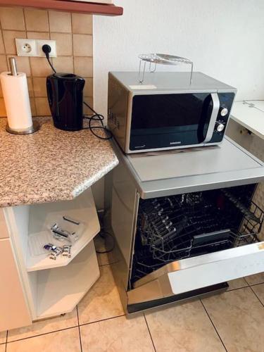 a microwave sitting on a counter in a kitchen at Grand appartement 2 chambres 5 pers max, vue panoramique avec parking in Mulhouse