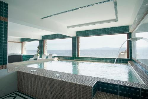 a swimming pool with a view of the ocean at Hotel La Pietra Restaurant & Spa in LʼÎle-Rousse