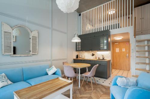 a living room with a blue couch and a table at RentPlanet - Apartamenty Zarembowicza in Wrocław