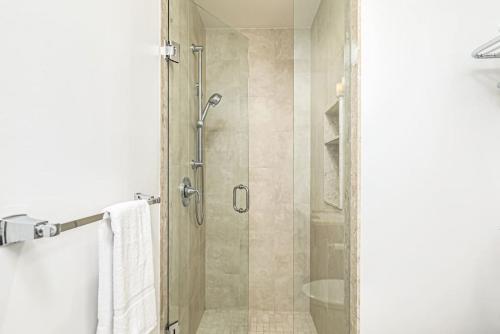 a shower with a glass door in a bathroom at Luxurious Rivergrass Blue Mountain Retreat in Blue Mountains