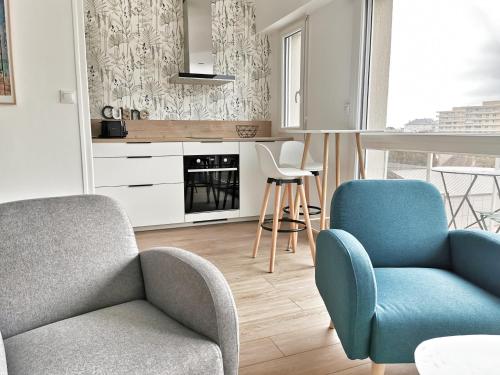 un salon avec un canapé et deux chaises dans l'établissement Appartement lumineux avec balcon et parking, à Cherbourg en Cotentin