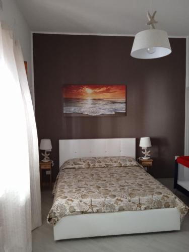 a bedroom with a bed and a painting on the wall at Mary Gery's Rooms in Castellammare del Golfo