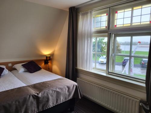 - une chambre avec un lit et une grande fenêtre dans l'établissement De Gouden Molen, à Rossum