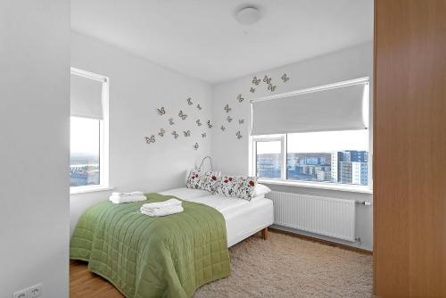 1 dormitorio blanco con 1 cama y 2 ventanas en Lovely 3-bedroom Apartment, en Reikiavik