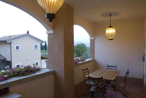 a balcony with a table and chairs and a window at Guadalupe Tuscany Resort in Braccagni