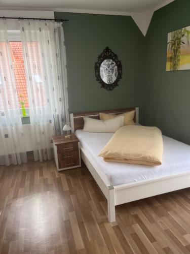 Gasthof Wulf في Bremen: غرفة نوم بسرير ابيض وجدار اخضر