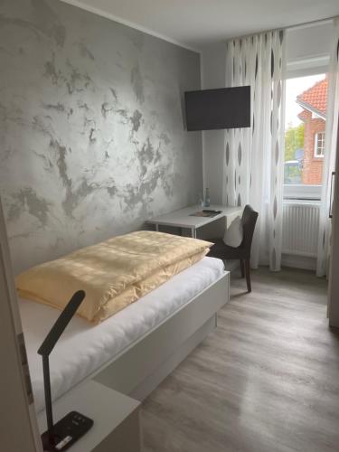 een slaapkamer met een bed, een bureau en een raam bij Gasthof Wulf in Bremen