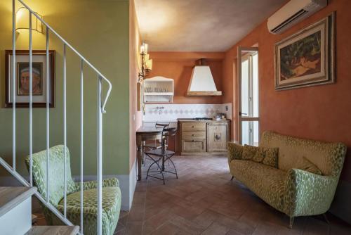 a living room with a staircase and a kitchen at Guadalupe Tuscany Resort in Braccagni