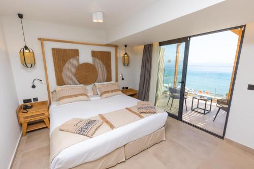 a bedroom with a large bed and a balcony at Cabana Blu Hotel & Suites in Kardamaina