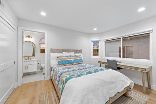 a white bedroom with a bed and a desk at Dana Point Deluxe in Dana Point